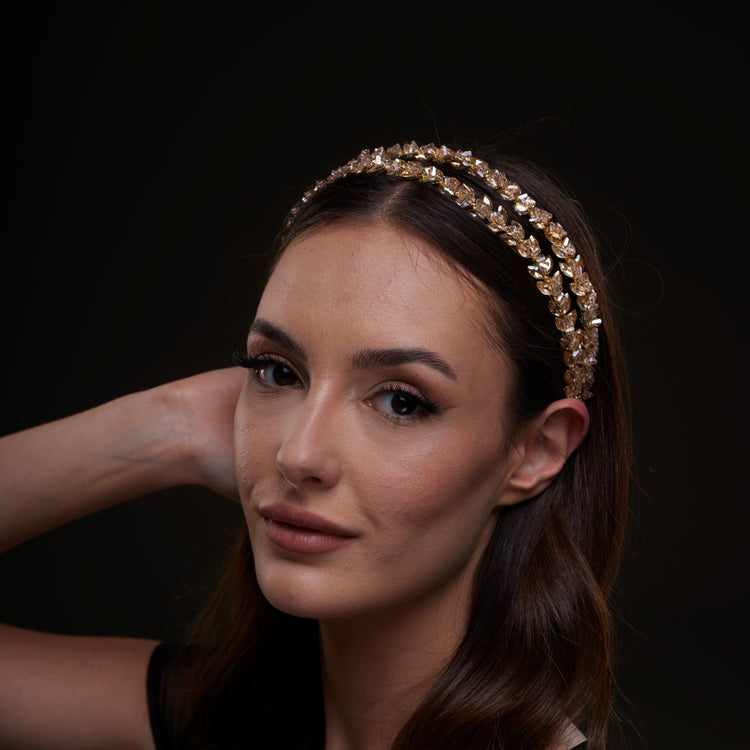 Woman wearing a decorative headband against a dark background