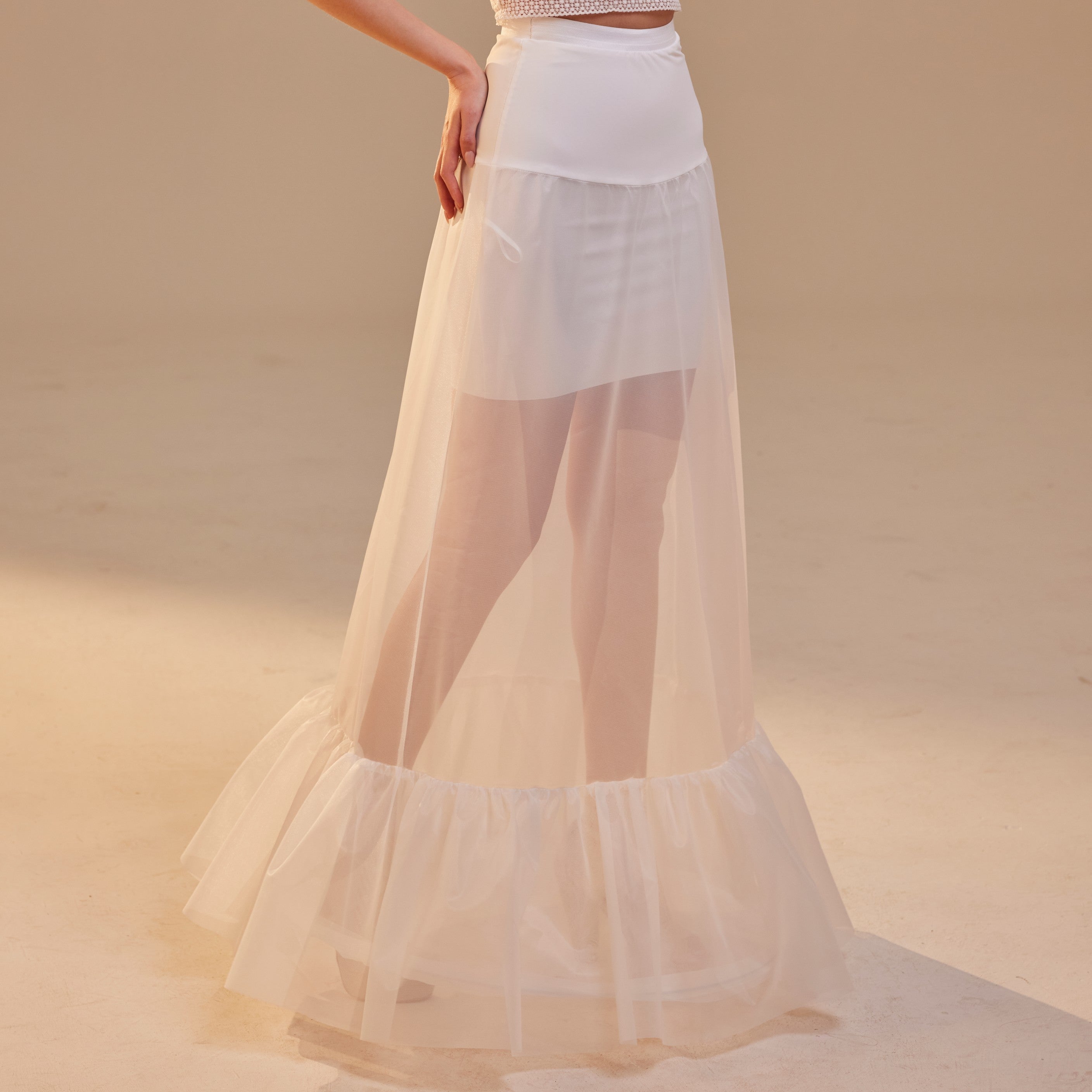 A white petticoat skirt with a waist corsage, designed to be worn under a bridal gown, providing volume and structure.